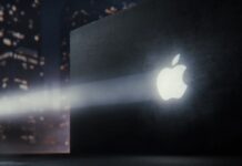 Apple Teaser Precedes Reported Touchscreen OLED MacBook Pro Reveal Apple logo projected on a dark wall with a nighttime city scene in the background