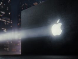 Apple logo projected on a dark wall with a nighttime city scene in the background